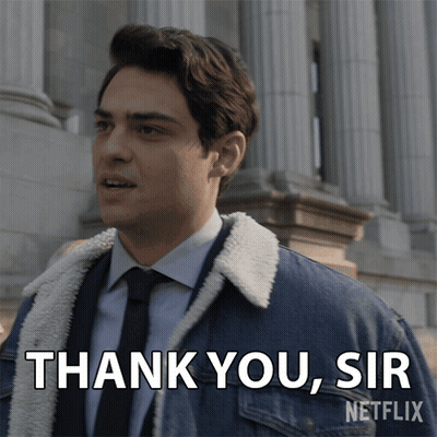 A Man In A Suit And Tie Says " Thank You Sir " In Front Of A Building GIF