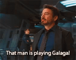A Man In A Suit And Tie Says " That Man Is Playing Galaga " GIF