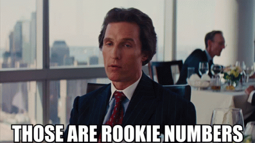 A Man In A Suit And Tie Says " Those Are Rookie Numbers " In Front Of A Window GIF