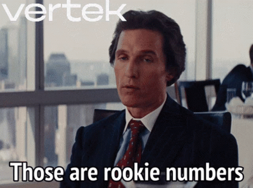 A Man In A Suit And Tie Says " Those Are Rookie Numbers " In Front Of A Window GIF