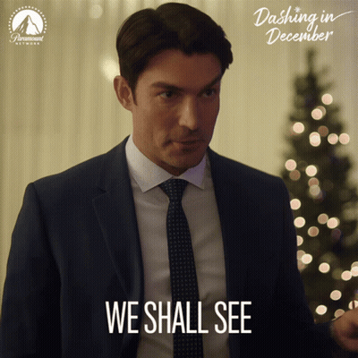 A Man In A Suit And Tie Says " We Shall See " In Front Of A Christmas Tree GIF