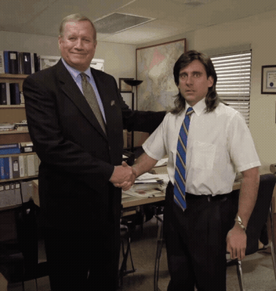 A Man In A Suit And Tie Shakes Hands With Another Man In A White Shirt And Tie GIF