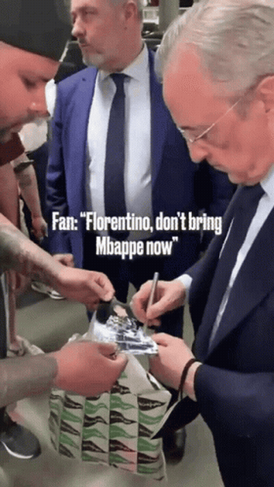 A Man In A Suit And Tie Signing A Piece Of Paper GIF