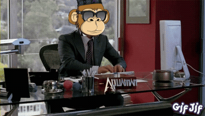 A Man In A Suit And Tie Sits At A Desk With A Sign That Says Atlantis GIF