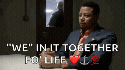 A Man In A Suit And Tie Sits At A Table With The Words " We " In It Together Fo ' Life GIF