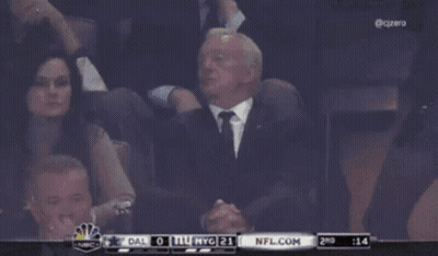 A Man In A Suit And Tie Sits In The Stands Watching A Game Between Dallas And Nyg GIF