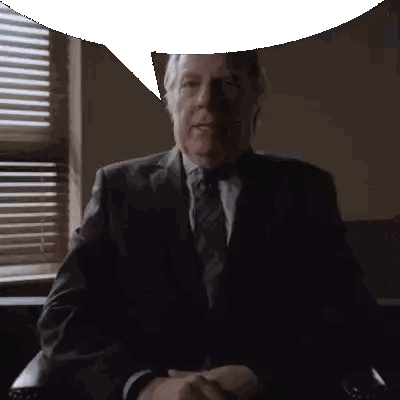 A Man In A Suit And Tie Sitting In Front Of A Window Sticker