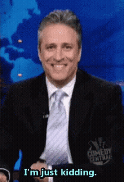 A Man In A Suit And Tie Smiles And Says I 'M Just Kidding GIF