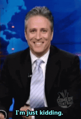 A Man In A Suit And Tie Smiles And Says I 'M Just Kidding GIF