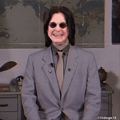 A Man In A Suit And Tie Smiles In Front Of A World Map GIF