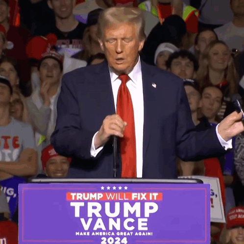 A Man In A Suit And Tie Stands At A Podium That Says Trump Will Fix It Trump Vance 2024 GIF