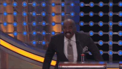 A Man In A Suit And Tie Stands At A Podium With A Microphone GIF