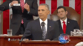 A Man In A Suit And Tie Stands At A Podium With A Sign That Says Live On It GIF