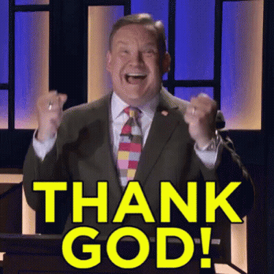 A Man In A Suit And Tie Stands At A Podium With His Fist In The Air And Says Thank God GIF