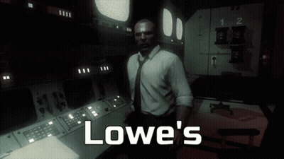 A Man In A Suit And Tie Stands In A Dark Room With The Words Lowe 'S Written On The Bottom GIF