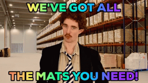 A Man In A Suit And Tie Stands In A Warehouse With The Words " We 'Ve Got All The Mats You Need " Above Him GIF