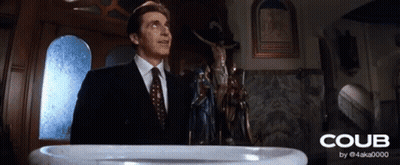A Man In A Suit And Tie Stands In Front Of A Baptismal Font That Says Coub On It GIF