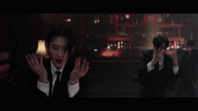 A Man In A Suit And Tie Stands In Front Of A Bar GIF
