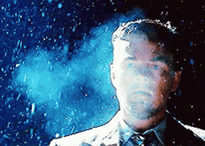A Man In A Suit And Tie Stands In Front Of A Blue Background GIF