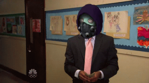 A Man In A Suit And Tie Stands In Front Of A Bulletin Board GIF