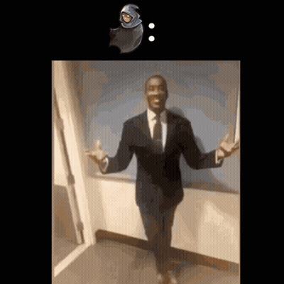 A Man In A Suit And Tie Stands In Front Of A Door GIF