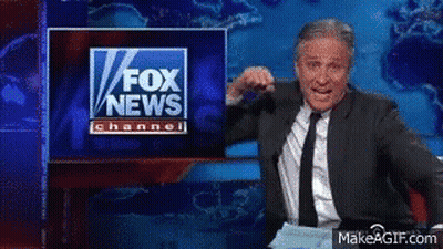 A Man In A Suit And Tie Stands In Front Of A Fox News Channel Sign GIF