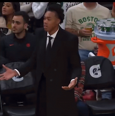 A Man In A Suit And Tie Stands In Front Of A Gatorade Stand GIF
