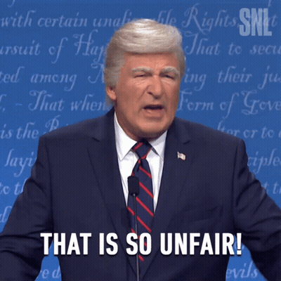 A Man In A Suit And Tie Stands In Front Of A Microphone And Says That Is So Unfair GIF