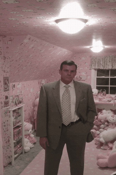 A Man In A Suit And Tie Stands In Front Of A Pink Hello Kitty Room GIF