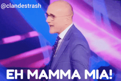 A Man In A Suit And Tie Stands In Front Of A Purple Background And Says " Eh Mamma Mia " GIF