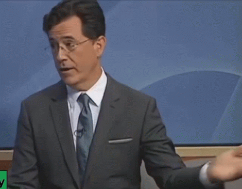 A Man In A Suit And Tie Stands In Front Of A Screen That Says ' Nbc News ' On It GIF