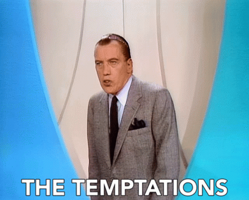 A Man In A Suit And Tie Stands In Front Of A Sign That Says " The Temptations " GIF