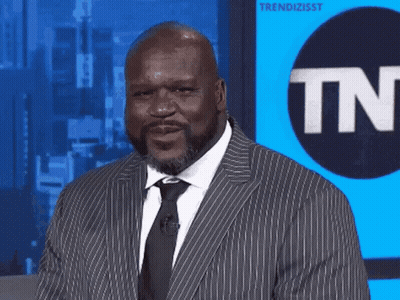 A Man In A Suit And Tie Stands In Front Of A Tnt Logo GIF