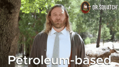 A Man In A Suit And Tie Stands In Front Of A Tree With The Words Petroleum-Based On The Bottom GIF