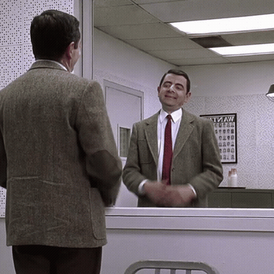 A Man In A Suit And Tie Stands In Front Of A Tvaw Poster GIF