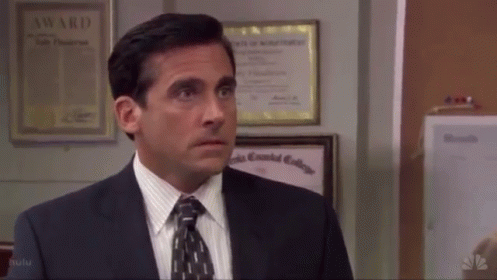 A Man In A Suit And Tie Stands In Front Of A Wall With A Certificate That Says Award On It GIF