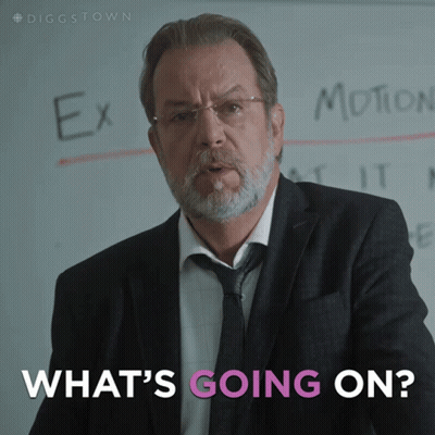 A Man In A Suit And Tie Stands In Front Of A White Board That Says Ex Motion And What 'S Going On GIF
