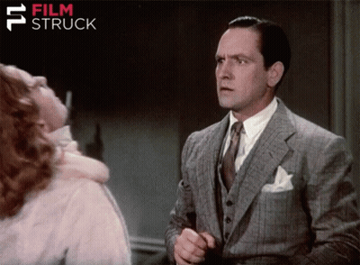 a man in a suit and tie stands in front of a woman with film struck written in the corner