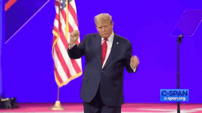 A Man In A Suit And Tie Stands In Front Of An American Flag And A Sign That Says Cspan.org GIF