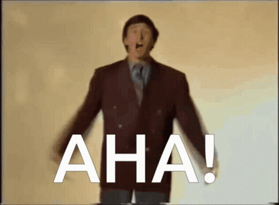 A Man In A Suit And Tie Stands In Front Of The Word Aha GIF