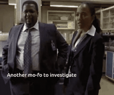 A Man In A Suit And Tie Stands Next To A Woman In A Lab With The Words Another Mo-Fo To Investigate GIF
