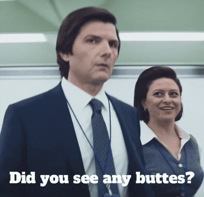 A Man In A Suit And Tie Stands Next To A Woman With The Words " Did You See Any Butts " Written Below Him GIF