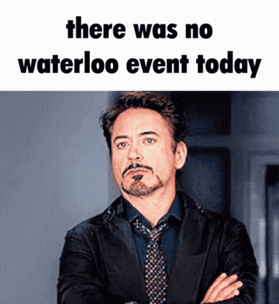 A Man In A Suit And Tie Stands With His Arms Crossed Under A Meme That Says There Was No Waterloo Event Today .. GIF