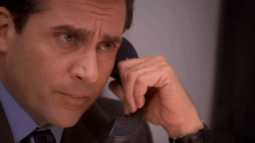 A Man In A Suit And Tie Talks On A Phone GIF