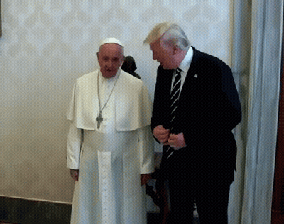 A Man In A Suit And Tie Talks To A Man In A White Robe GIF