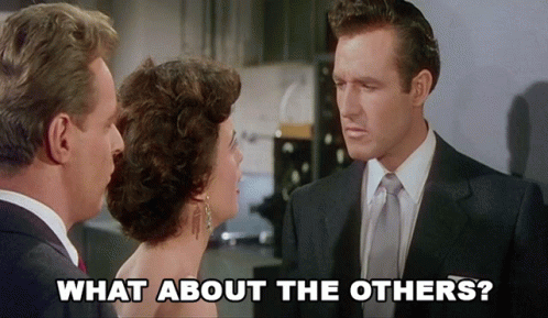 A Man In A Suit And Tie Talks To A Woman In A Dress With The Words " What About The Others " Above Him GIF