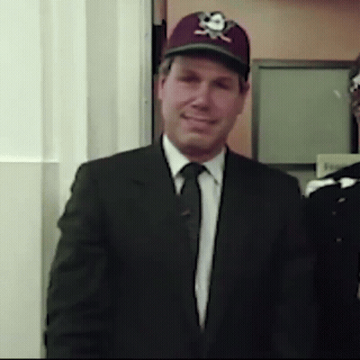A Man In A Suit And Tie Wearing A Baseball Cap With A Skull And Crossbones On It GIF
