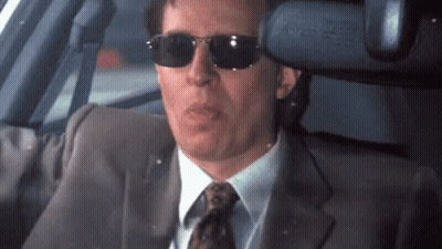 A Man In A Suit And Tie Wearing Sunglasses GIF