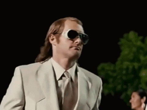 A Man In A Suit And Tie Wearing Sunglasses . GIF