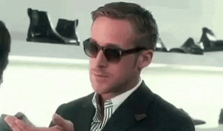 A Man In A Suit And Tie Wearing Sunglasses Is Clapping His Hands . GIF